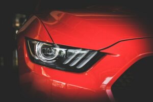 Close up image of a headlight on a red car