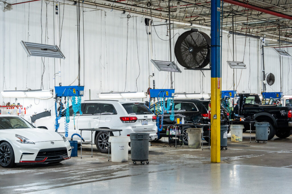 Image of various trucks and cars being detailed in the Crystal Clean facility